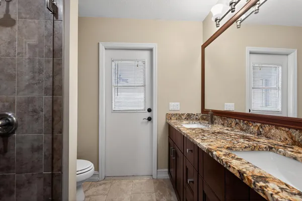 a bathroom with a granite countertop sink and a mirror