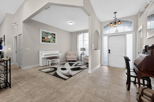 a living room with furniture a chandelier and a dining table