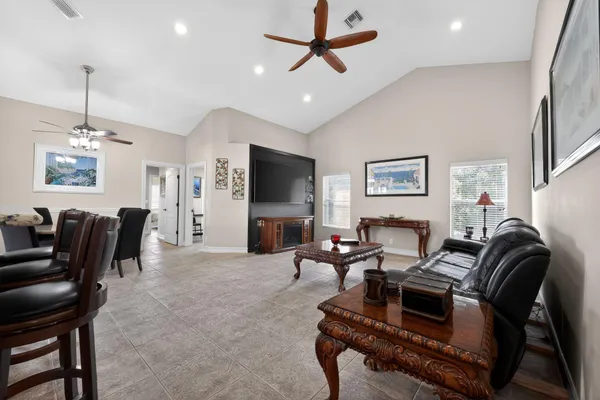 a living room with furniture a flat screen tv and a window