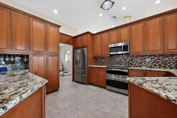 a large kitchen with stainless steel appliances granite countertop a stove and a sink