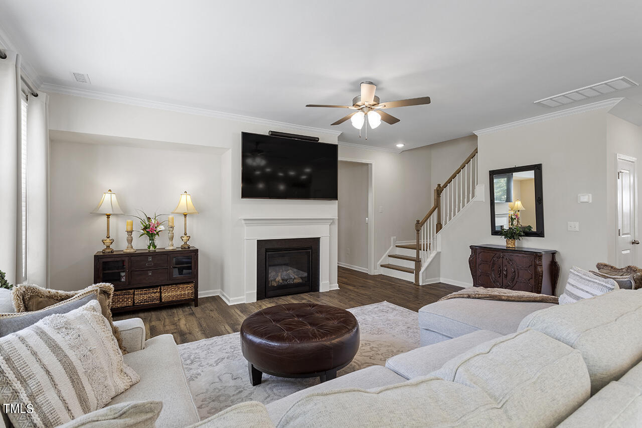 131 Hopper Circle Clayton, NC 27520 - Photo 11 of 39 a living room with furniture a flat screen tv and a fireplace