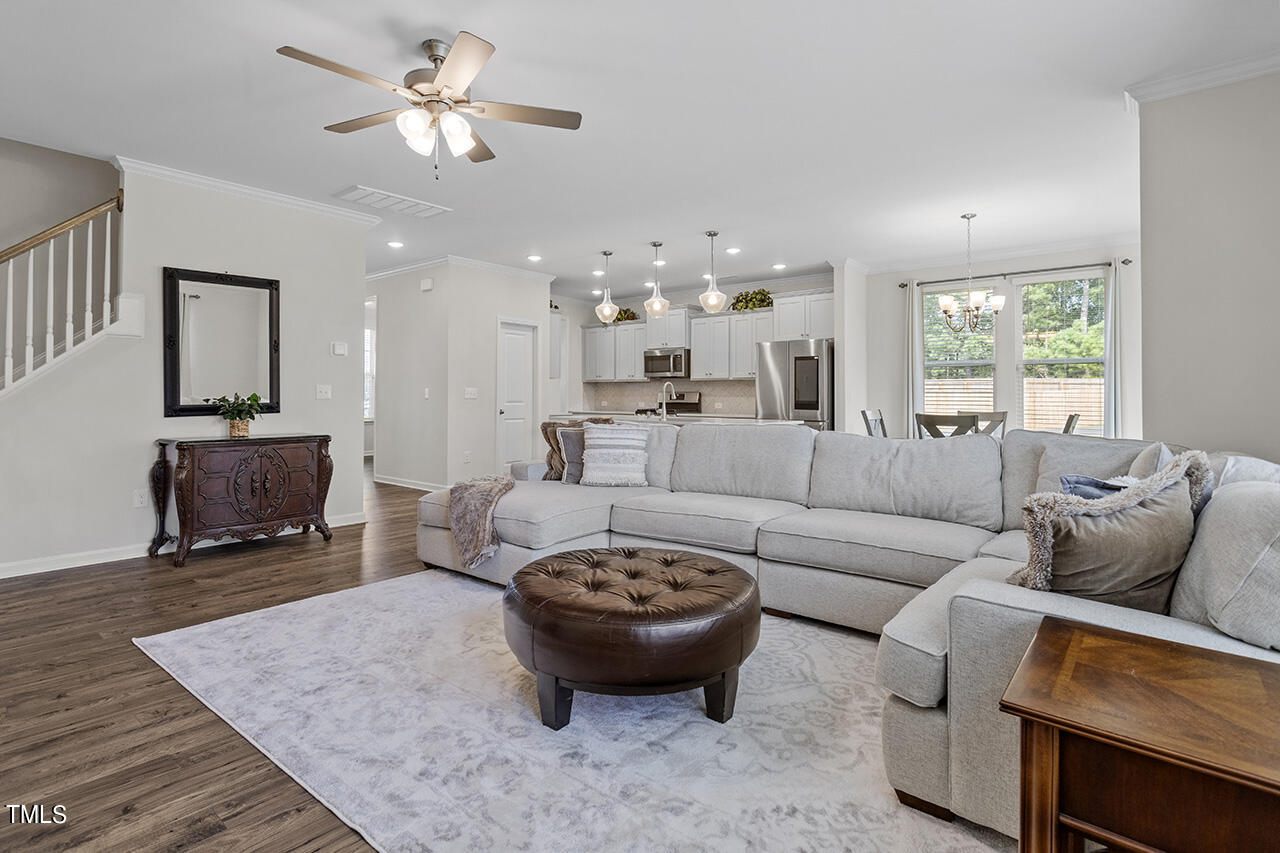131 Hopper Circle Clayton, NC 27520 - Photo 13 of 39 a living room with furniture a fireplace and a chandelier