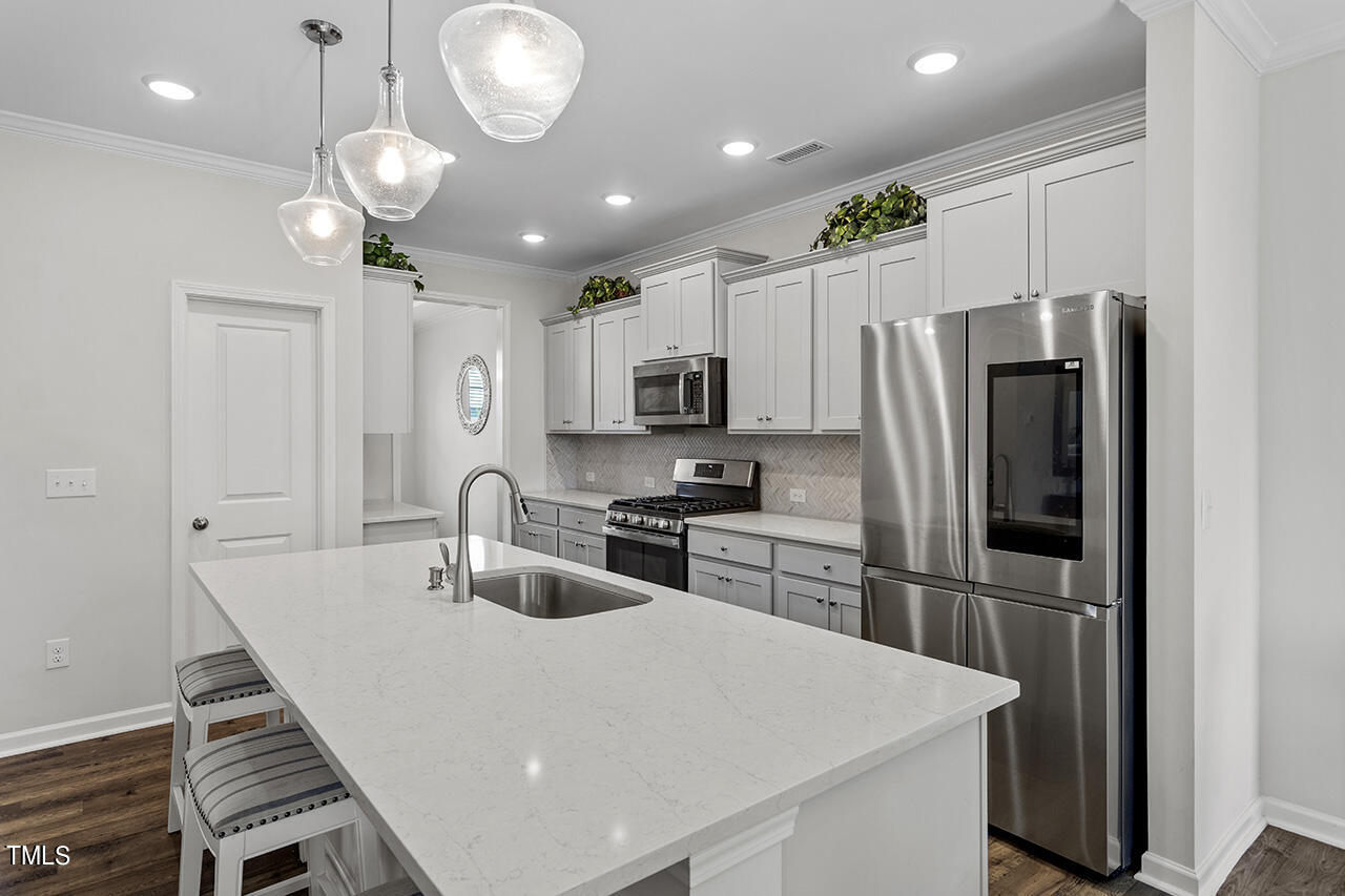 131 Hopper Circle Clayton, NC 27520 - Photo 14 of 39 a kitchen with stainless steel appliances a refrigerator sink and stove