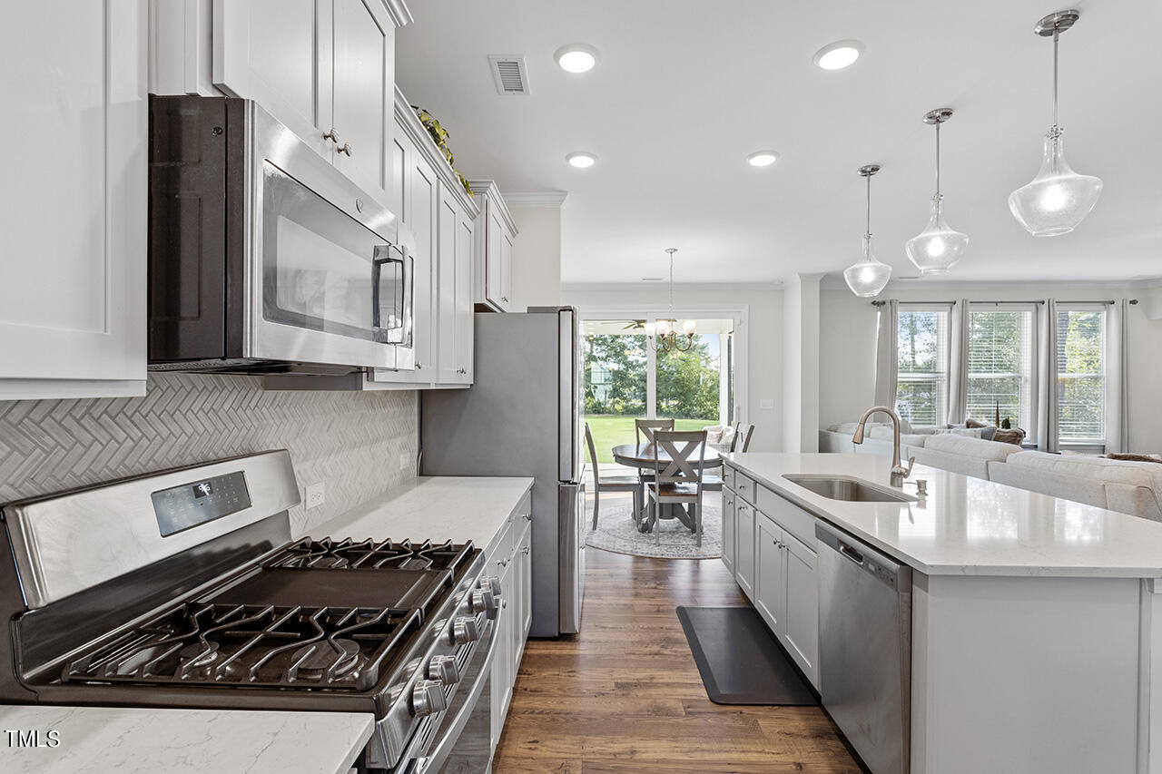 131 Hopper Circle Clayton, NC 27520 - Photo 16 of 39 a kitchen with lots of counter top space a sink stainless steel appliances and cabinets