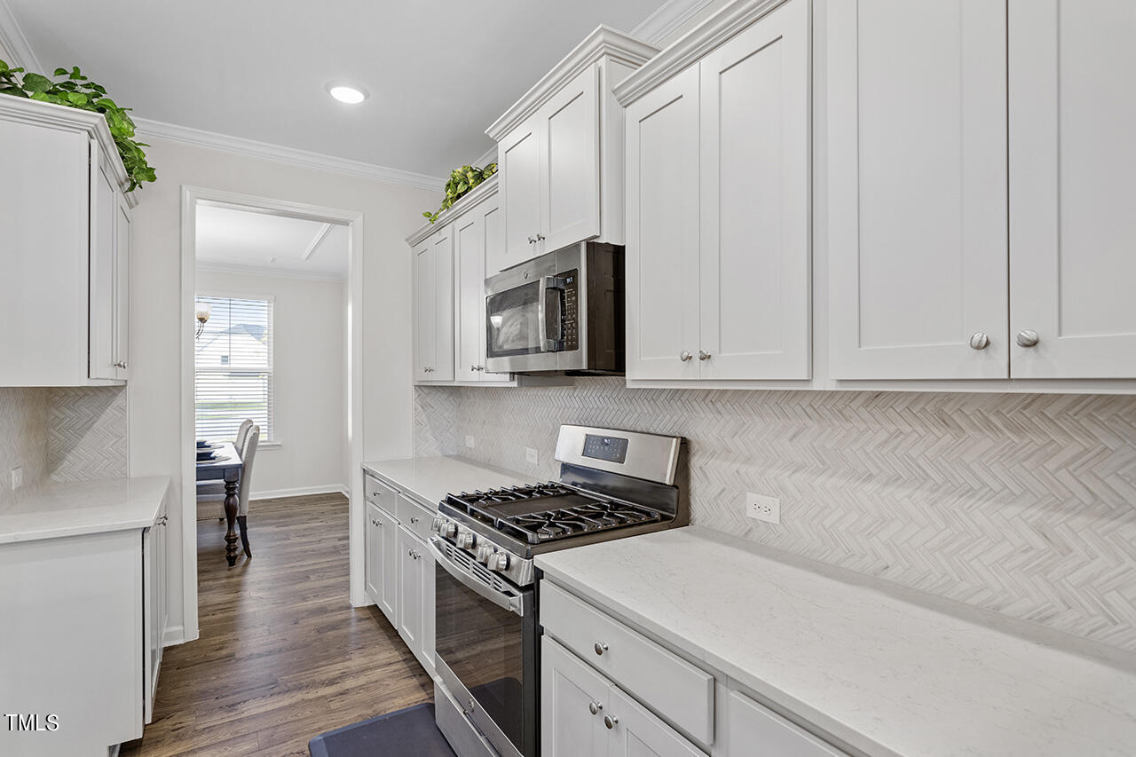 131 Hopper Circle Clayton, NC 27520 - Photo 18 of 39 a kitchen with granite countertop a sink a stove and cabinets
