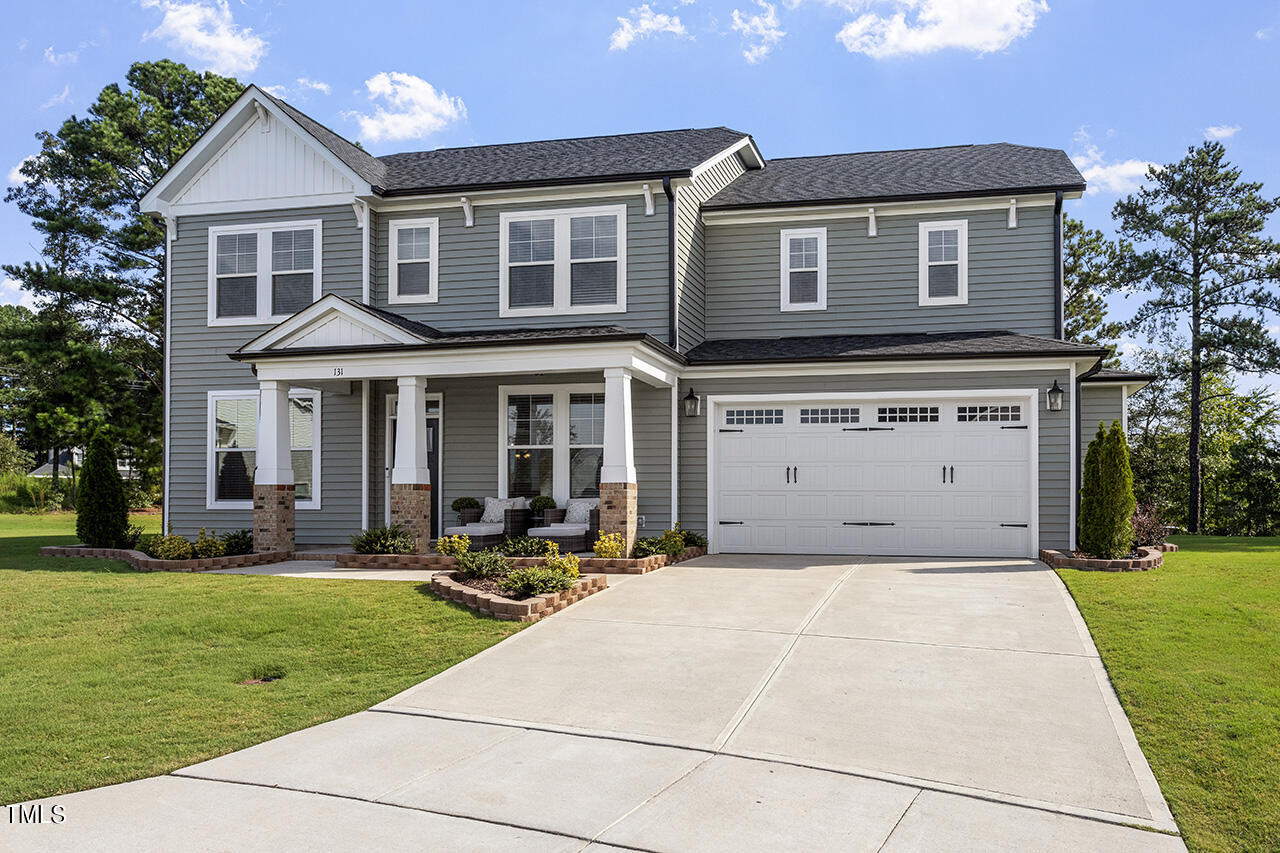 131 Hopper Circle Clayton, NC 27520 - Photo 2 of 39 a front view of a house with a yard table and chairs
