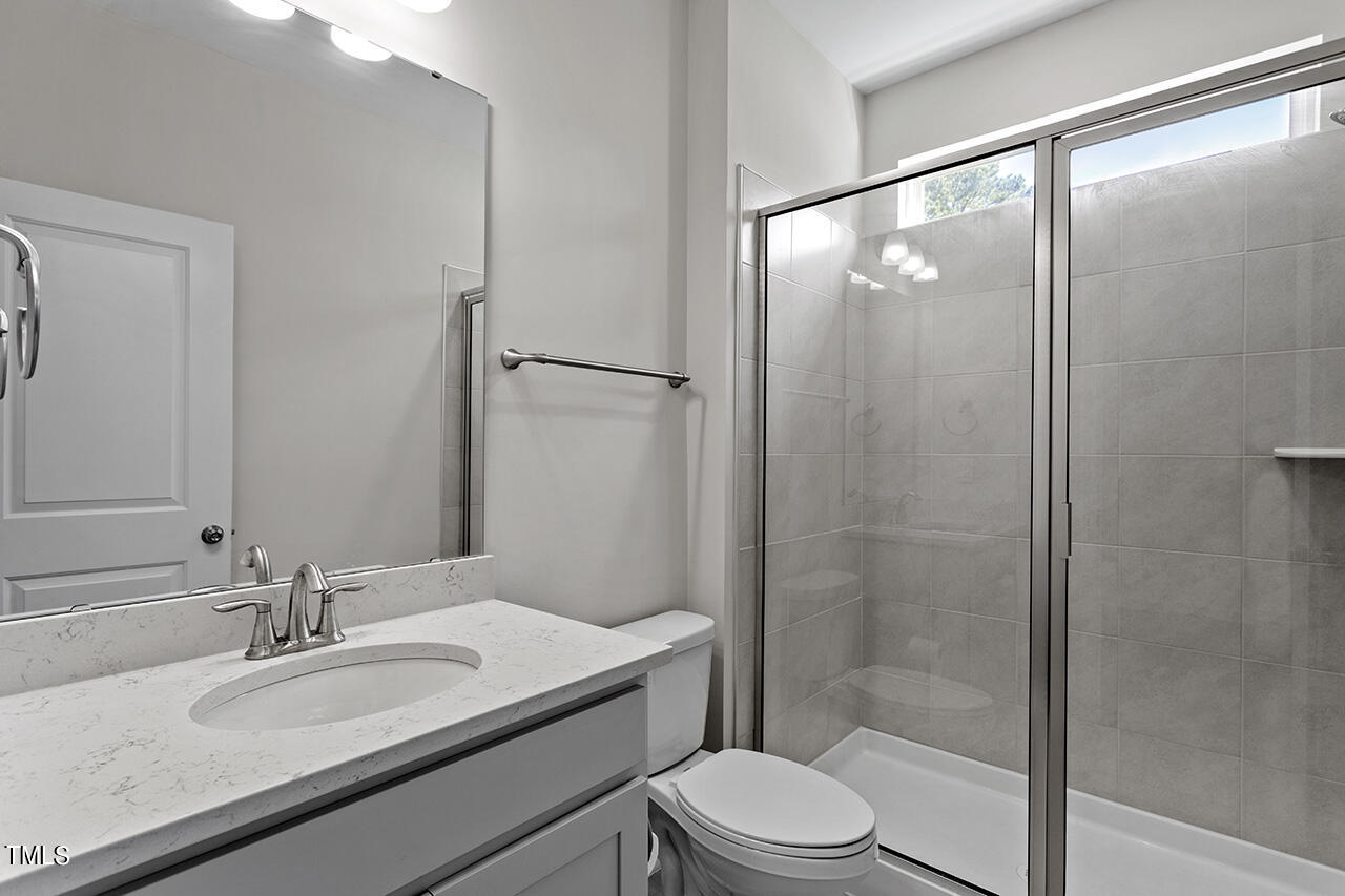 131 Hopper Circle Clayton, NC 27520 - Photo 24 of 39 a bathroom with a granite countertop sink toilet and shower