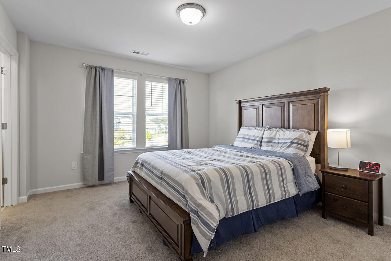 131 Hopper Circle Clayton, NC 27520 - Photo 28 of 39 a spacious bedroom with a bed and a lamp