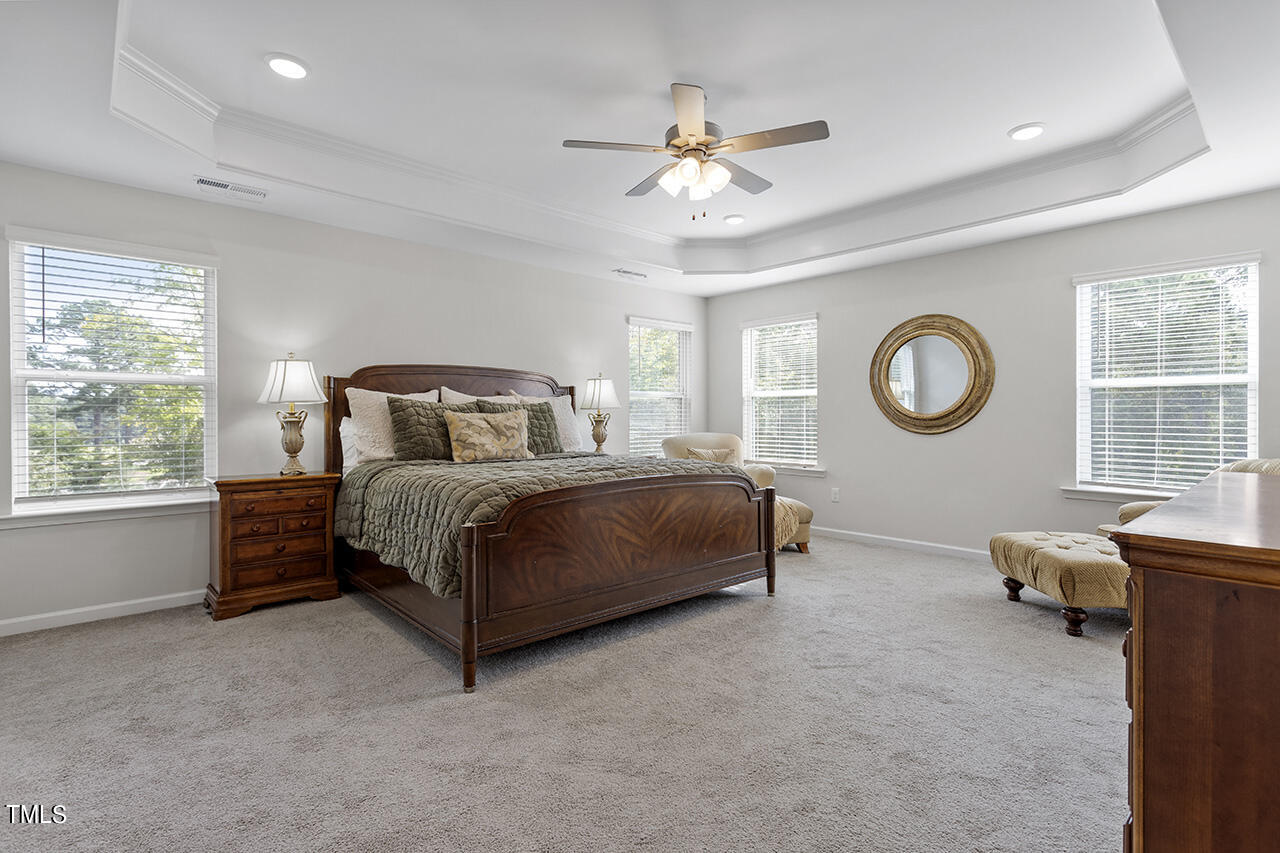 131 Hopper Circle Clayton, NC 27520 - Photo 33 of 39 a bedroom with a bed and a chandelier