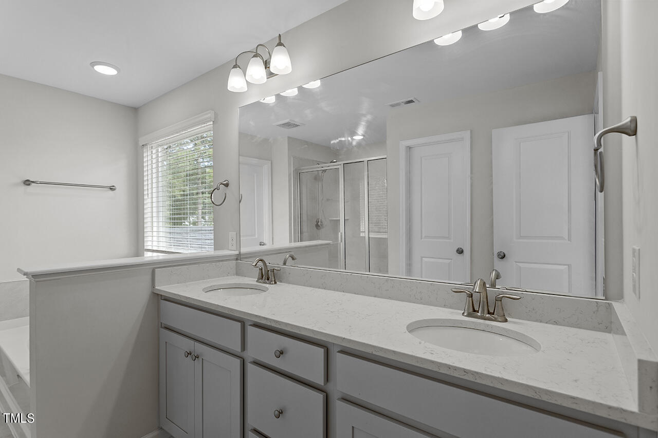 131 Hopper Circle Clayton, NC 27520 - Photo 35 of 39 a bathroom with double vanity sinks and a mirror