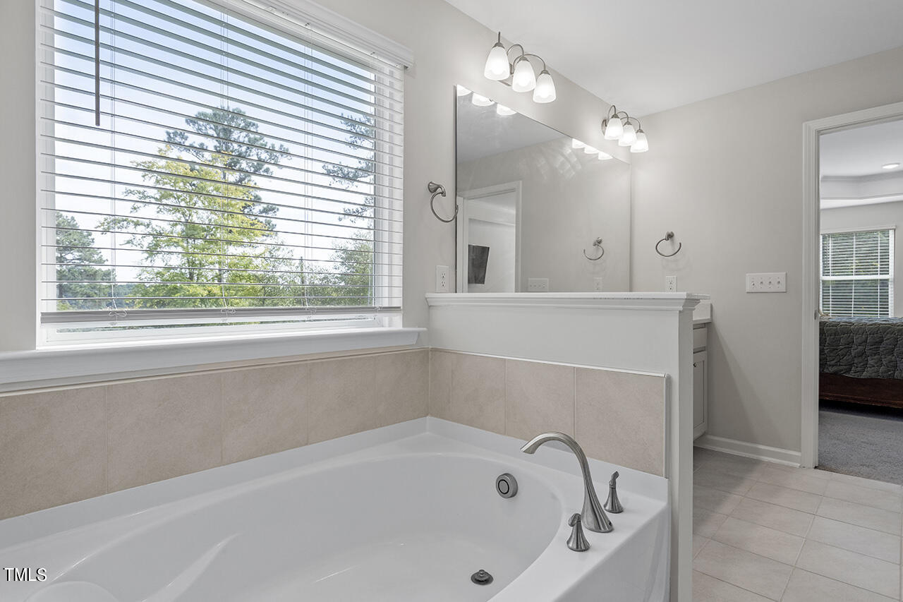 131 Hopper Circle Clayton, NC 27520 - Photo 36 of 39 a bathroom with a bathtub a window and a shower
