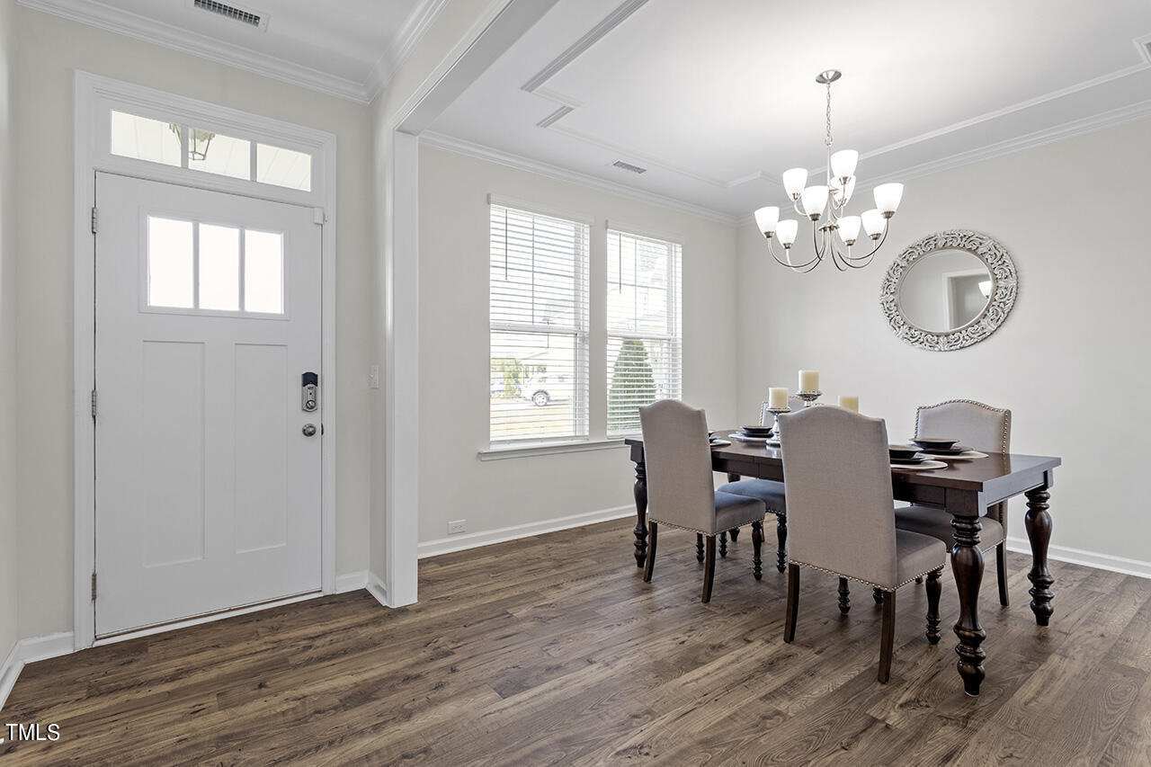 131 Hopper Circle Clayton, NC 27520 - Photo 9 of 39 a view of a dining room with furniture a chandelier and wooden floor