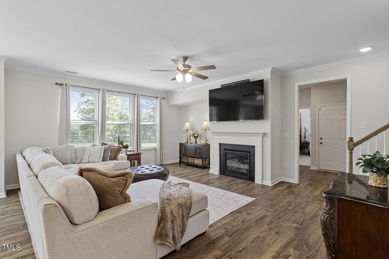 131 Hopper Circle Clayton, NC 27520 - Photo 10 of 39 a living room with furniture a fireplace and a flat screen tv