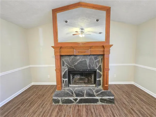 a living room with a fireplace and wooden floor