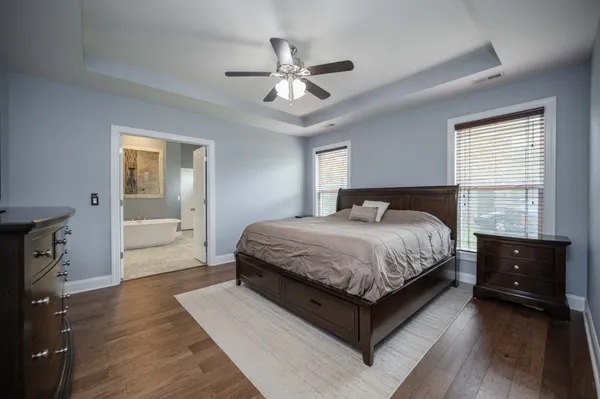 a spacious bedroom with a bed and a dresser