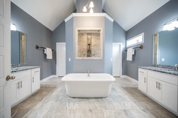 a spacious bathroom with a double vanity sink mirror and bathtub