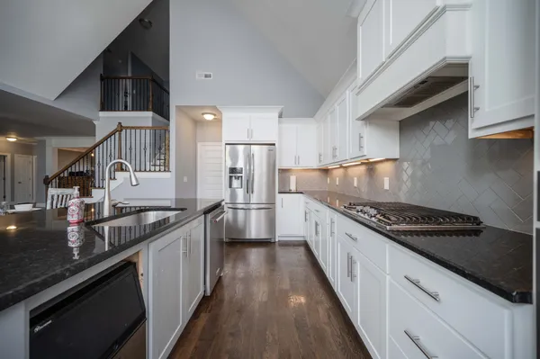 a kitchen with stainless steel appliances granite countertop a stove a sink and a refrigerator