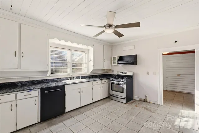a kitchen with stainless steel appliances granite countertop stove top oven microwave and cabinets