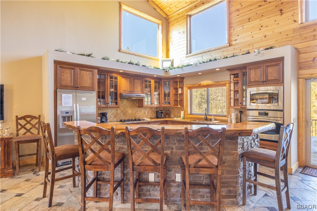 42324 Eagle Ridge Big Bear Lake, CA 92315 - Photo 17 of 50 a dining hall with stainless steel appliances kitchen island granite countertop a table and chairs