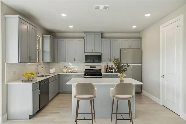 a kitchen with a sink a microwave and cabinets