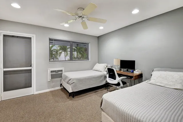 a bedroom with two beds and a ceiling fan