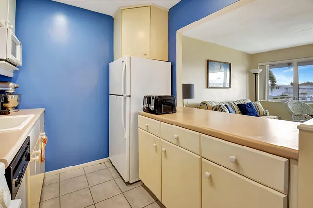 a kitchen with a refrigerator sink and cabinets