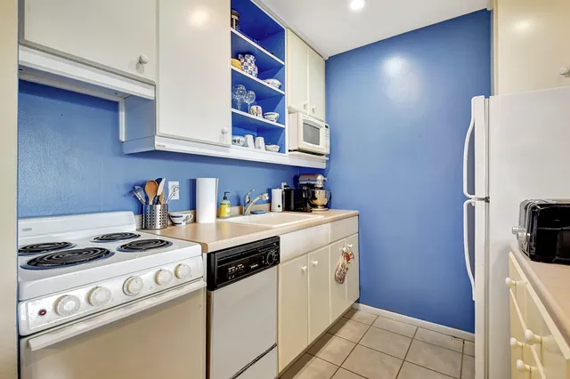 a kitchen with stainless steel appliances granite countertop a refrigerator and a stove