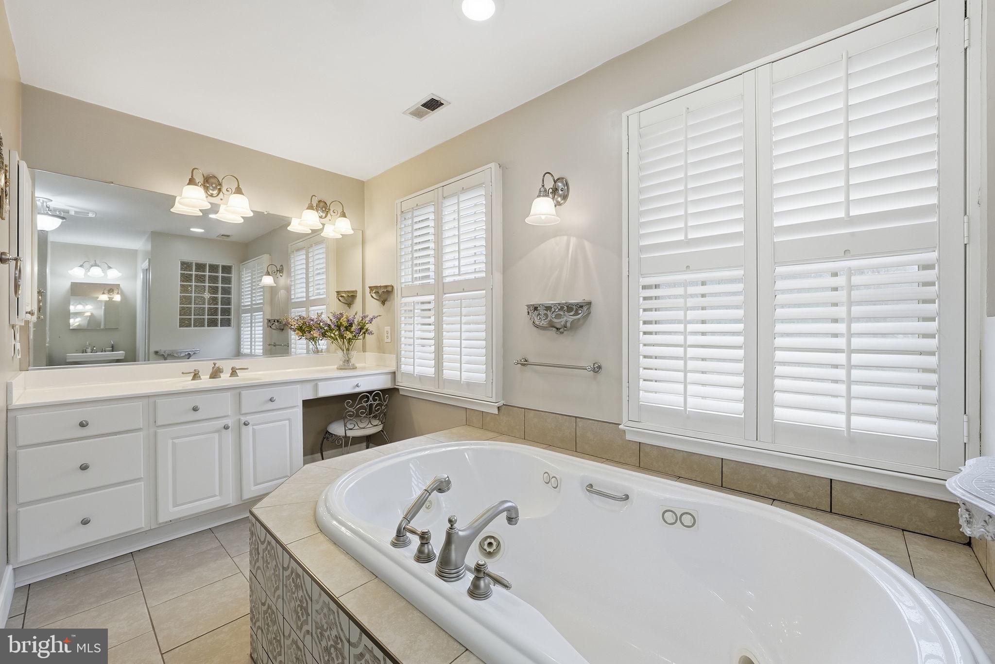 140 Hoile Lane Huntingtown, MD 20639 - Photo 26 of 44 a spacious bathroom with a tub a sink and a large mirror