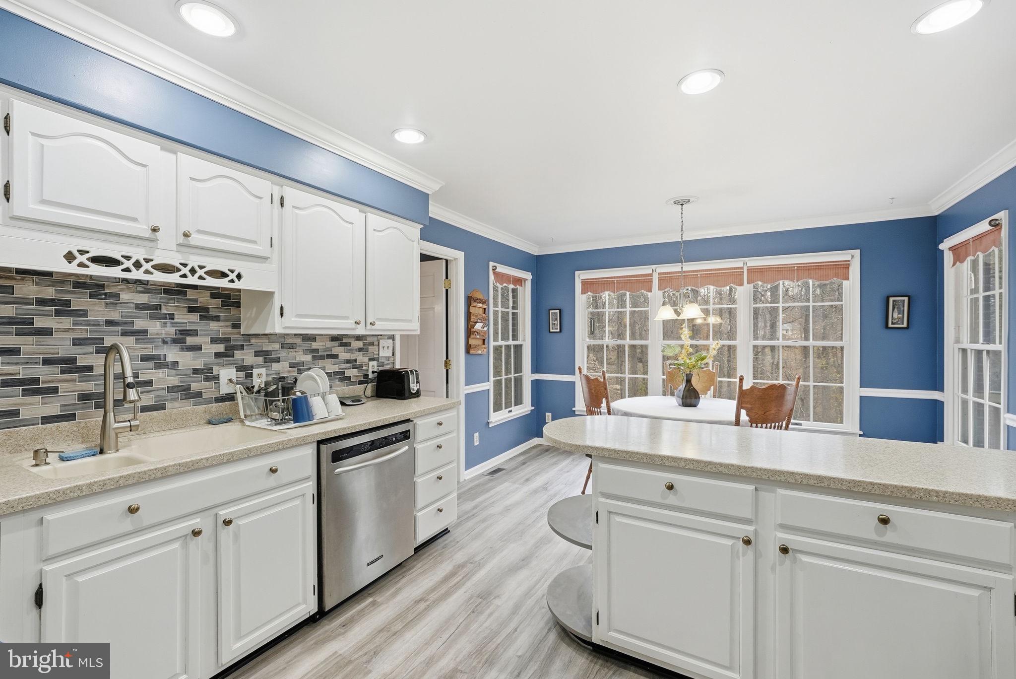 140 Hoile Lane Huntingtown, MD 20639 - Photo 10 of 44 a kitchen with white cabinets and white appliances