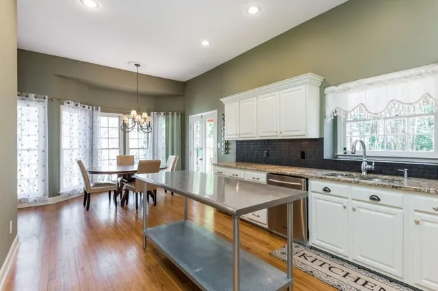 a kitchen with granite countertop a sink window and stainless steel appliances