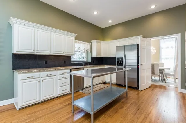a large kitchen with cabinets counter top space a sink stainless steel appliances and cabinets