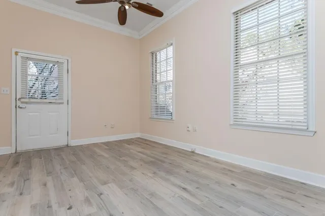 an empty room with wooden floor and windows