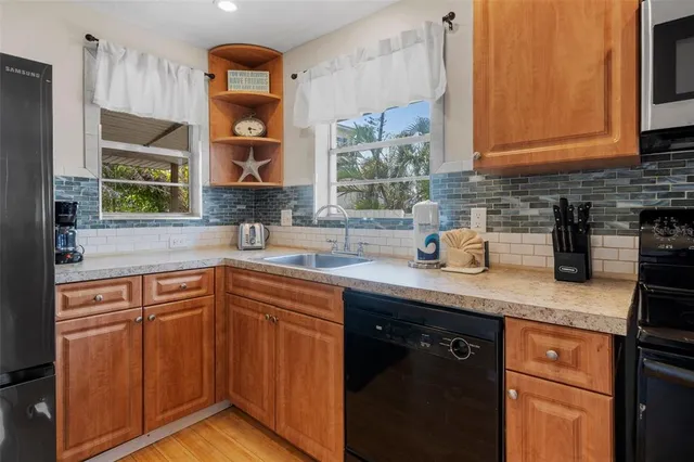 a kitchen with stainless steel appliances granite countertop a sink stove and cabinets