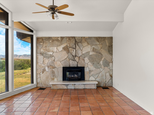 15680 North Beaver Dam Road Collinston, UT 84306 - Photo 7 of 49 Stone-clad fireplace with hearth, gas insert, and substantial natural light from floor-to-ceiling windows