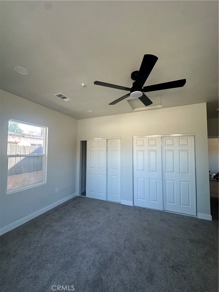 6597 Valaria Drive Highland, CA 92346 - Photo 5 of 8 a view of a livingroom with a ceiling fan & windows