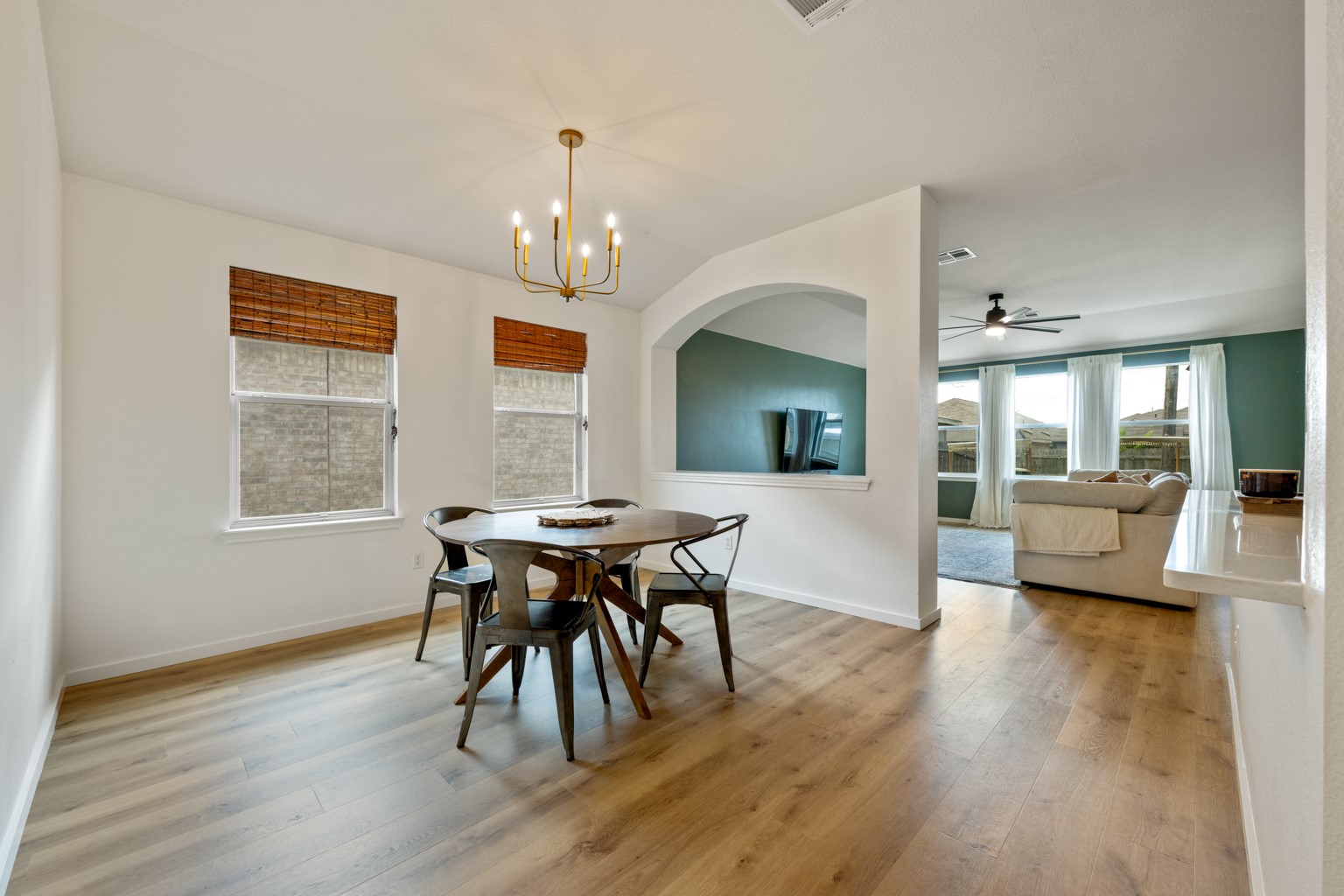 1391 Stone Rim Loop Buda, TX 78610 - Photo 12 of 35 Natural light floods this inviting dining area, highlighting the warm wood flooring and open concept.