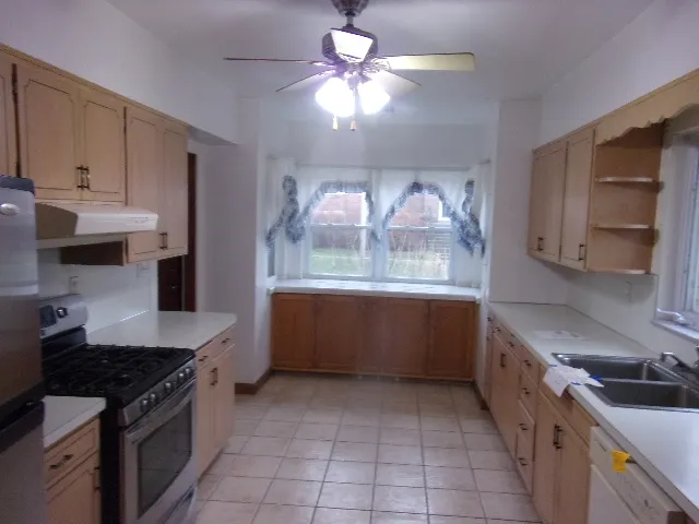 a kitchen with stainless steel appliances a sink stove and cabinets