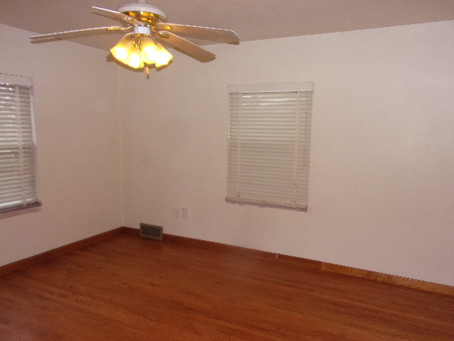 102 West Center Street Le Roy, IL 61752 - Photo 7 of 11 an empty room with a wooden floor and chandelier fan