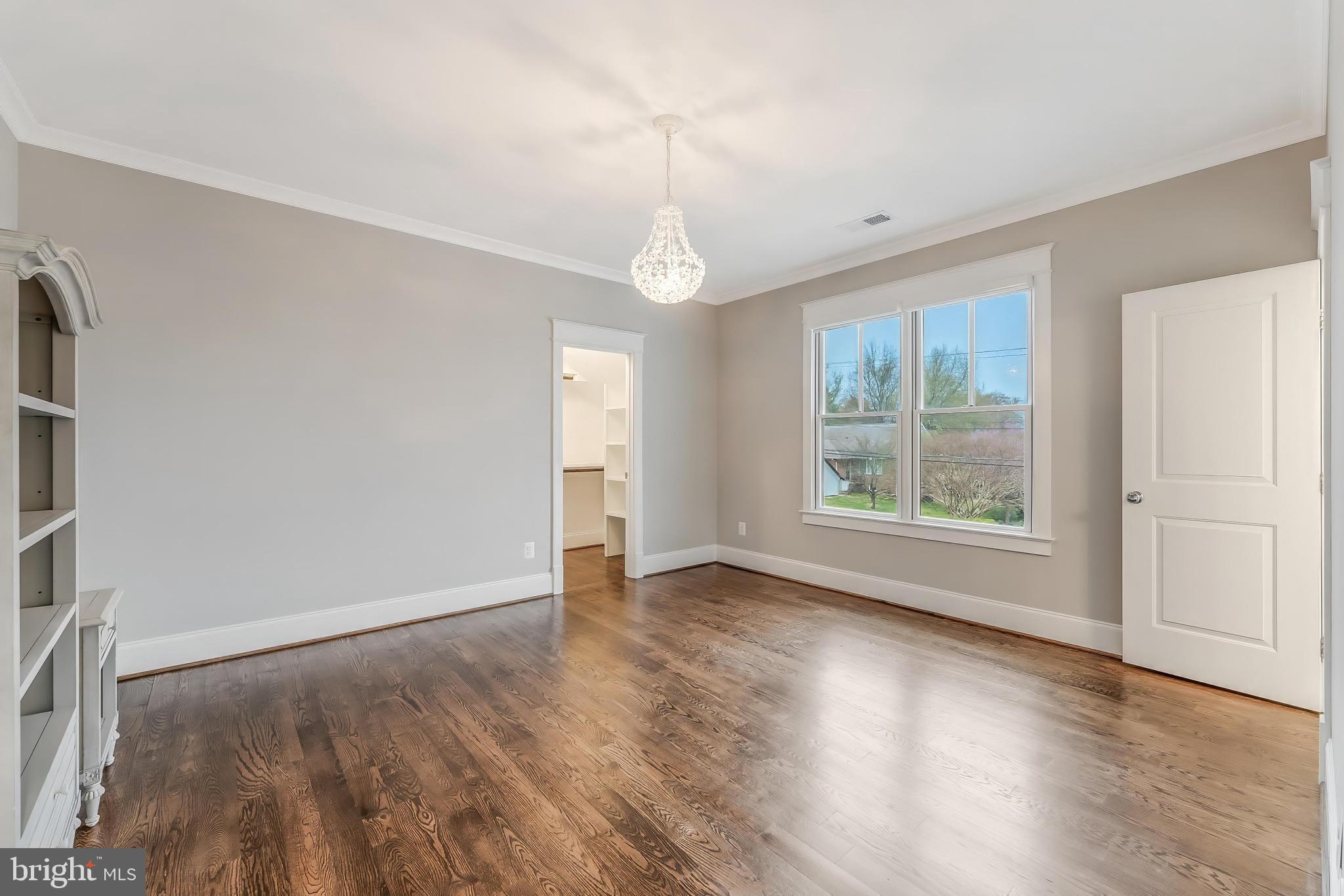 6805 Lumsden Street McLean, VA 22101 - Photo 85 of 123 an empty room with wooden floor chandelier and windows
