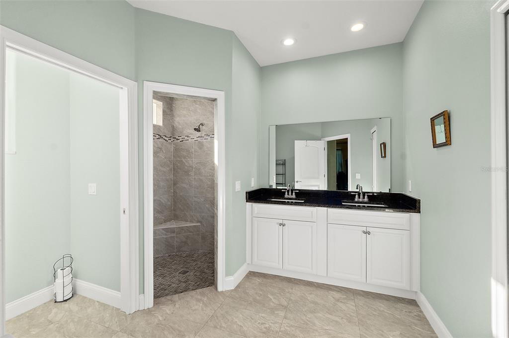 6 Wavecrest Place Palm Coast, FL 32164 - Photo 17 of 22 a bathroom with a granite countertop sink a mirror and shower