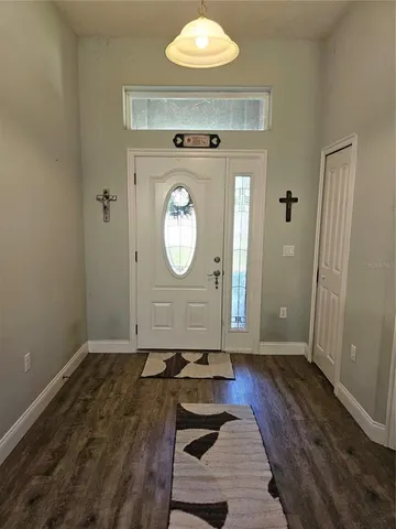 a view of a livingroom with wooden floor and a large mirror