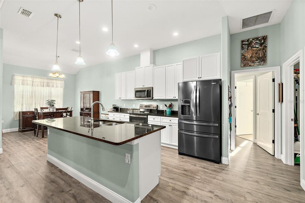 6 Wavecrest Place Palm Coast, FL 32164 - Photo 7 of 22 a kitchen with kitchen island a refrigerator a stove a sink and a center island