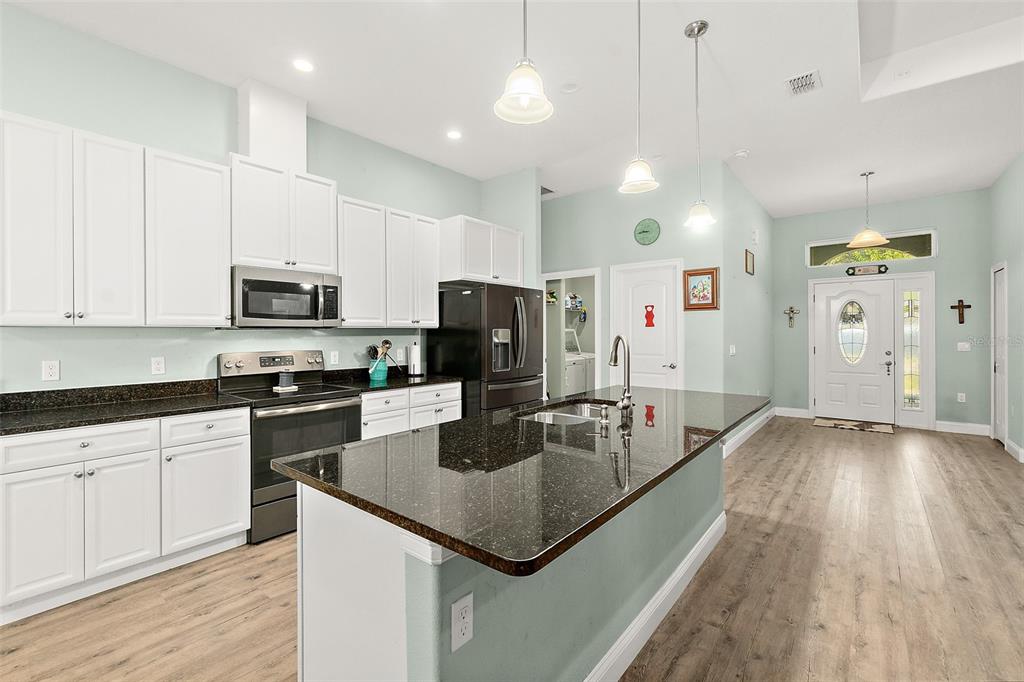 6 Wavecrest Place Palm Coast, FL 32164 - Photo 8 of 22 a kitchen with stainless steel appliances granite countertop a sink refrigerator and cabinets