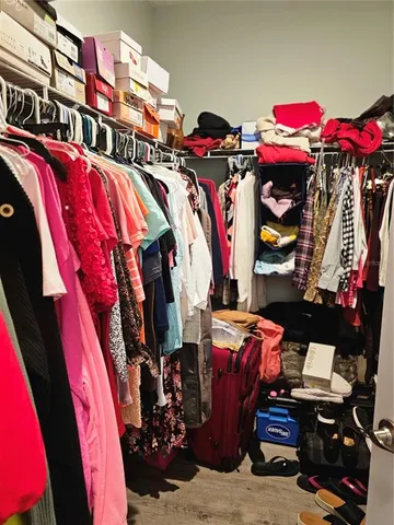 a view of walk in closet with clothes