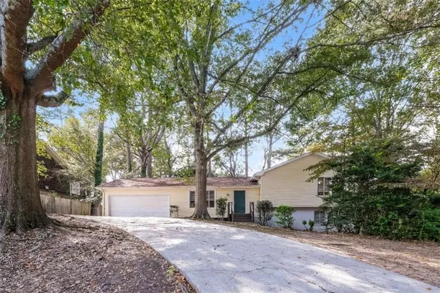 a white house that has a tree in front of it