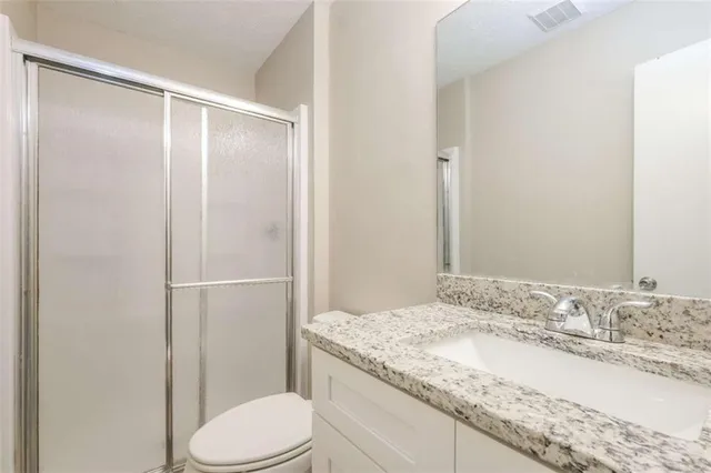 a bathroom with a granite countertop sink toilet and shower
