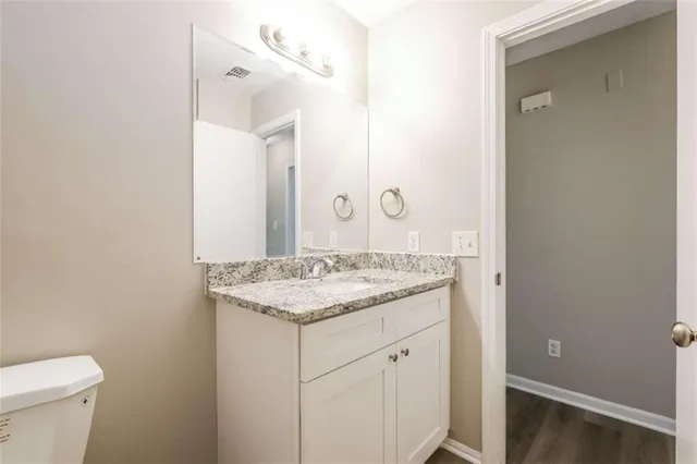 a bathroom with a granite countertop sink and a mirror