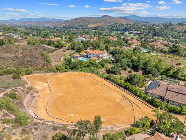an aerial view of residential houses with outdoor space and trees
