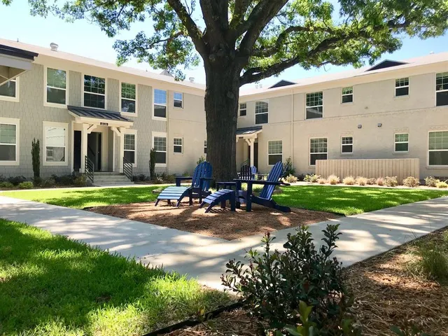 a view of a house with backyard and sitting area