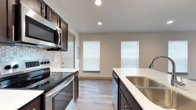 a kitchen with stainless steel appliances a stove a sink and a microwave